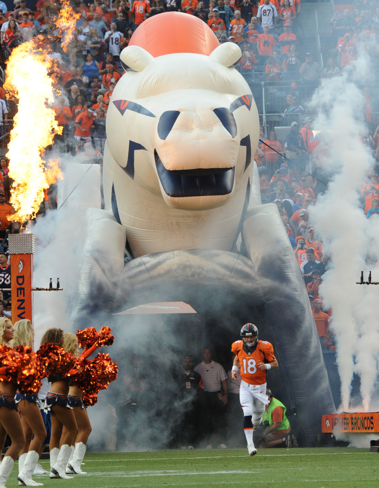 Denver quarterback Peyton Manning runs on the the field as the Broncos are introduced before the start of their preseason game against the Seattle Seahawks Thursday, Aug. 7, 2014, at Sports Authority Field at Mile High in Denver. (The Gazette, Christian Murdock)
